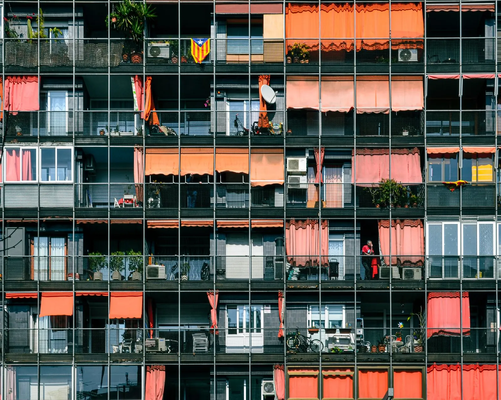 Facade of a large apartment block with balconies and coloured awnings