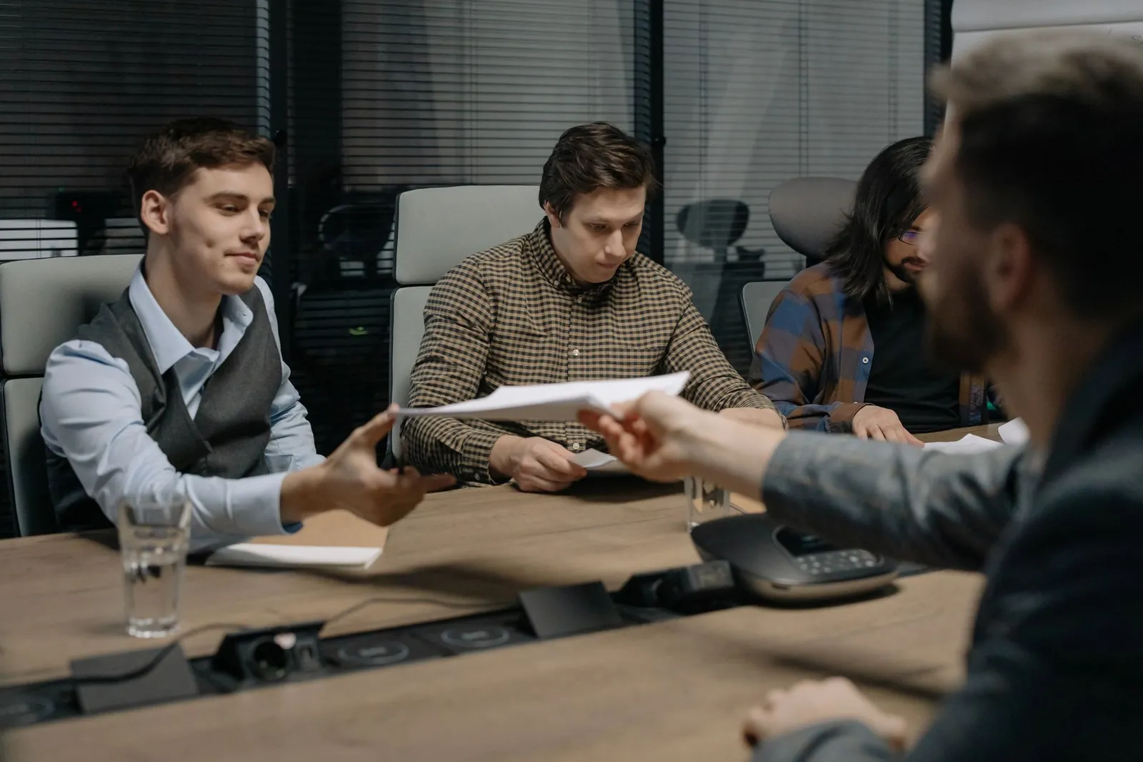 Papers being handed across a table during a meeting